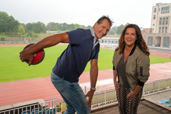Lars Riedel und Katarina Witt im Chemnitzer Sportforum ©MDR 2024 Lars Riedel und Katarina Witt lächeln sind im Chemnitzer Sportforum und lächeln in die Kamera