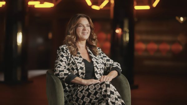Katarina Witt sitzt lächelnd in einem Sessel.