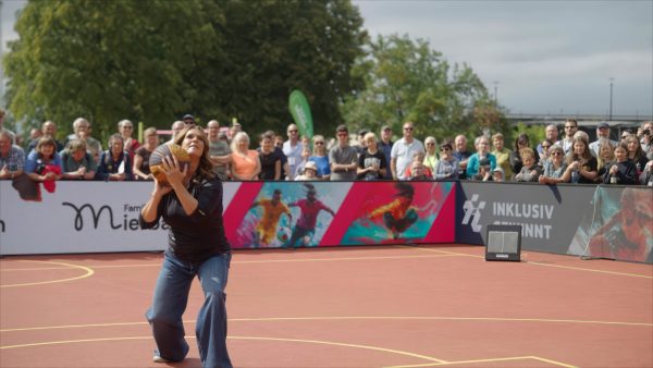 Katarina Witt wirft einen Basketball.